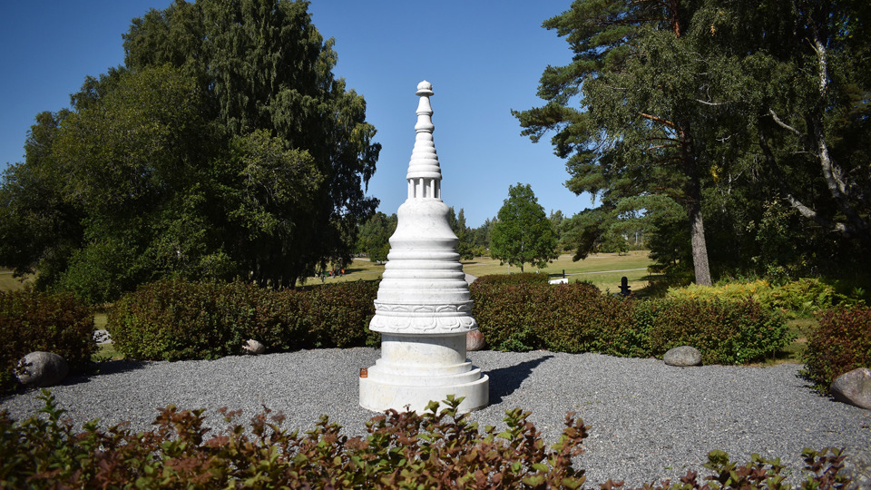 Buddhistisk ceremoniplats med en vit stupa.