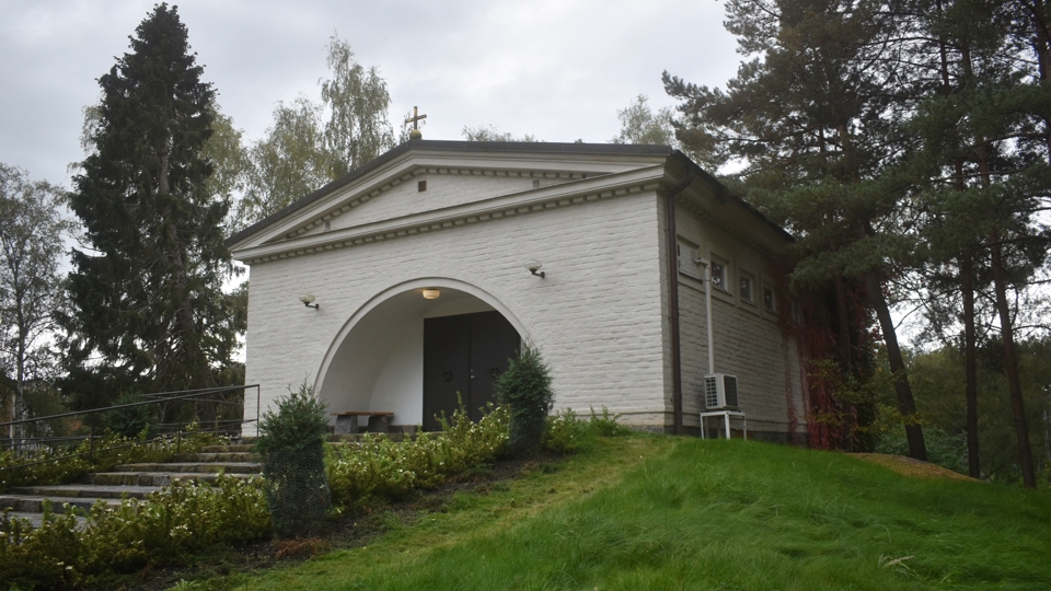 En vit kapellbyggnad på en begravningsplats.