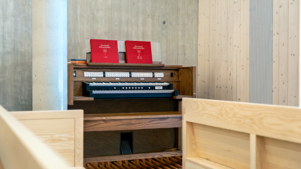Orgel som står mot en ljus trävägg.